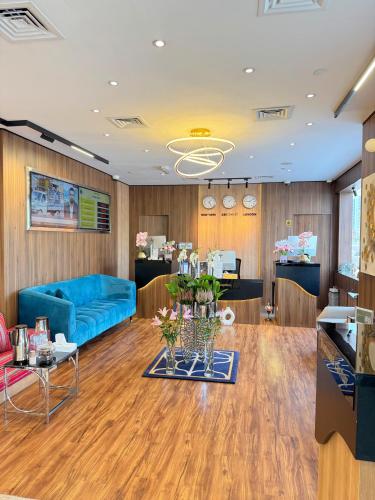 a living room with a blue couch and wooden floors at AG Hotel in Abu Dhabi