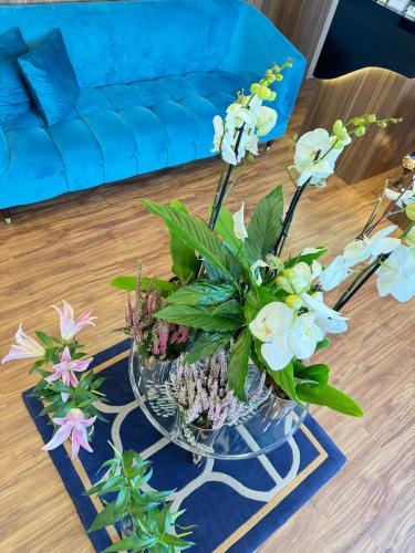 a vase filled with flowers on a table at AG Hotel in Abu Dhabi