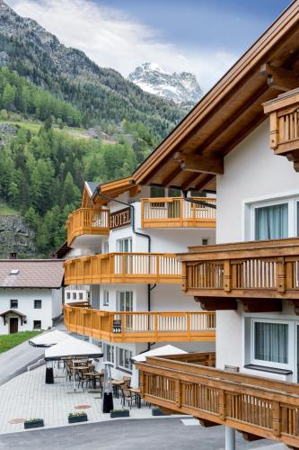 a hotel with wooden balconies and tables and tables at A Casa Saphir Appartement-Hotel in Sölden