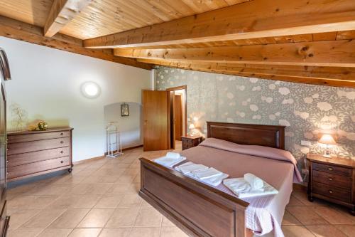 a bedroom with a bed and a wooden ceiling at AGRITURISMO COLOMBARE TEBOI in Lazise