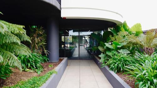 an entrance to a building with plants and a hallway at Simply Luxe - 2BR 2Bath Stay in Melbourne