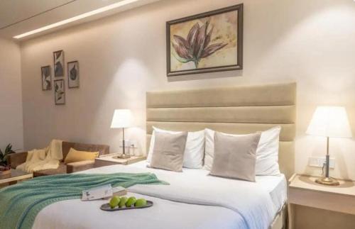 um quarto de hotel com uma cama com um prato de fruta em Golden glow in aipl joystreet em Gurgaon