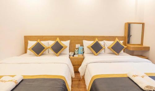 two beds in a hotel room with a mirror at Soda Hotel Đà Lạt in Da Lat