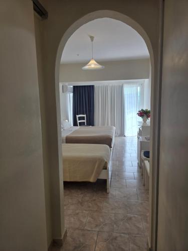 a hotel room with a bed and a hallway at Odysseus Hotel in Paleokastritsa