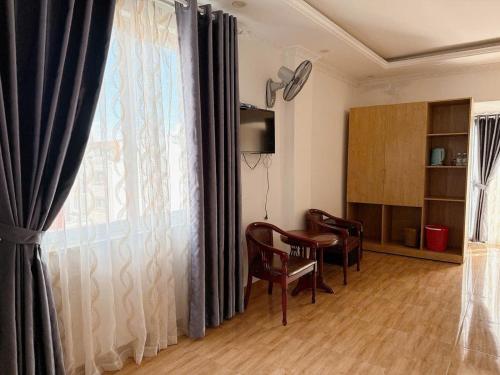 a living room with a window with chairs and a table at Soda Hotel Đà Lạt in Da Lat