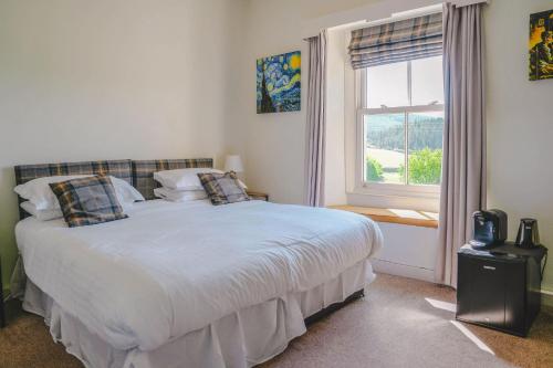 a bedroom with a large white bed with a window at New Inn Appletreewick in Appletreewick