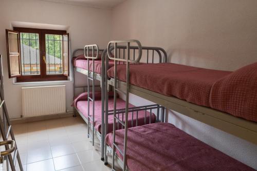 a group of bunk beds in a room with a window at KYOMU Resort in Velilla del Río Carrión