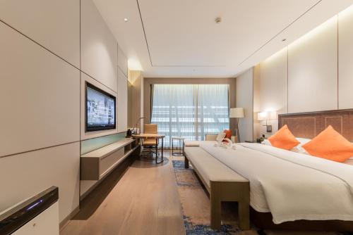 a hotel room with a large bed and a television at Changzhou Wenpu Hotel Changzhou Culture Square Branch in Changzhou