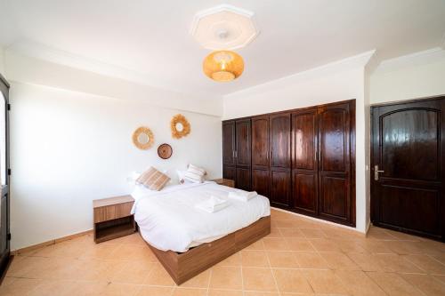 a bedroom with a bed and a wooden cabinet at Appartement Dar Tamraght in Tamraght Ouzdar
