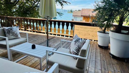 a patio with a couch and a table on a deck at Boutique Hotel Niesenblick - direkt am Thunersee gelegen mit SELF CHECK IN & digitaler Rezeption in Oberhofen am Thunersee