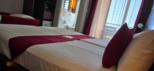 a bedroom with a large bed with red pillows at Tulip Inn Sainte Clotilde, La Réunion in Saint-Denis