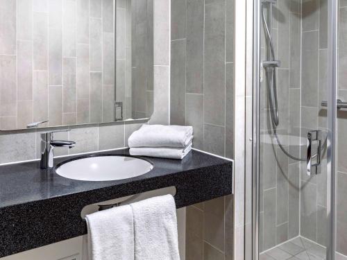 a bathroom with a sink and a shower at B&B HOTEL Mittenwald in Mittenwald