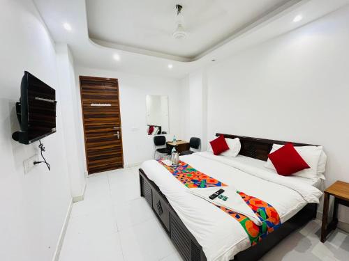 a bedroom with a bed and a flat screen tv at Hotel Lotus Villa - Near Nehru Enclave Metro Station in New Delhi