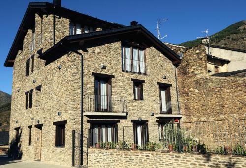 a large brick building with windows on it at Casa Rural La Comella in Tirvia