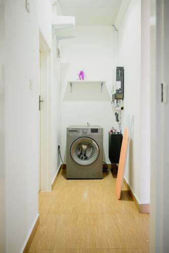 a laundry room with a washing machine in a hallway at Villa Stone Apartments in Lusaka