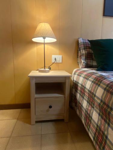 a nightstand with a lamp on it next to a bed at Casa Monte Zebio in Asiago