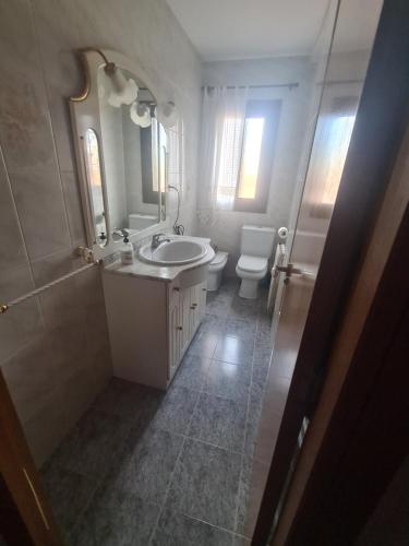 a white bathroom with a sink and a toilet at Apartamento Museo in Teruel