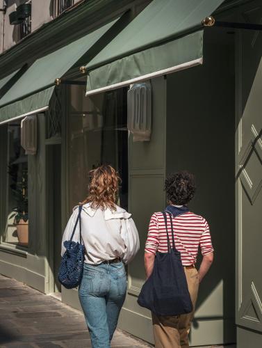 two people walking down a street looking in a store window at Hotel Suzie Blue in Paris