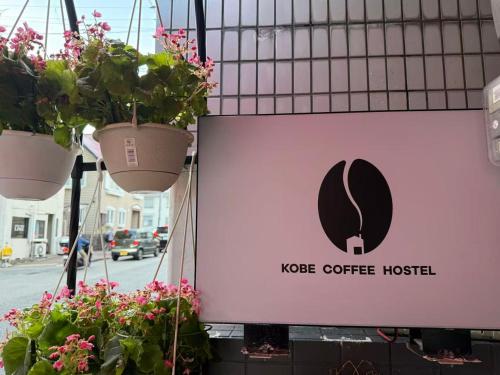 a sign for a coffee house with potted plants at KOBE coffee hostel in Kobe