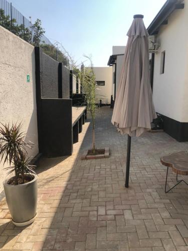 an umbrella sitting on a patio next to a building at ECO-WILD Luxury Suites in Windhoek
