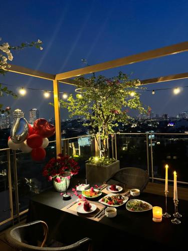 a table with plates of food on a balcony at night at Hanoi Riverview Boutique Hotel & Apartment in Hanoi