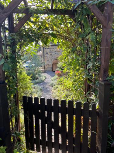 a garden with a wooden gate and a fence at The Granary with hot tub - 2 miles from Skipton in Carleton