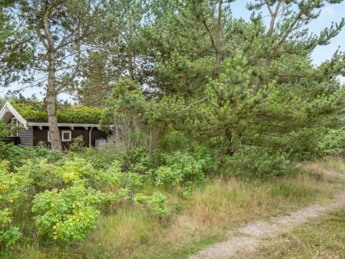 a house with a grass roof with a dirt road at Holiday Home Alfi - 150m from the sea by Interhome in Sæby