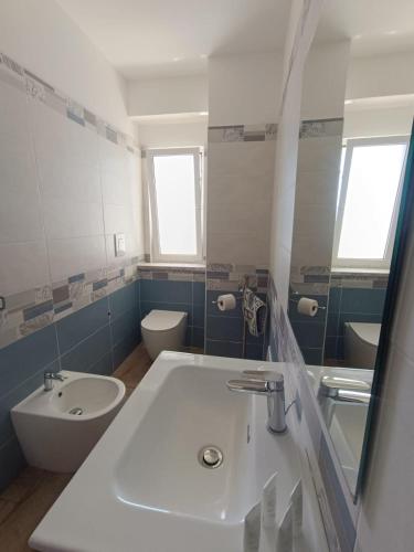 a bathroom with a white sink and a toilet at Solleone - Appartamento 4B in Paestum