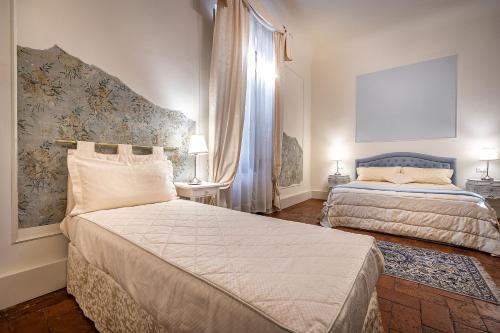 a hotel room with two beds and a window at Dimora Bandinelli in Florence