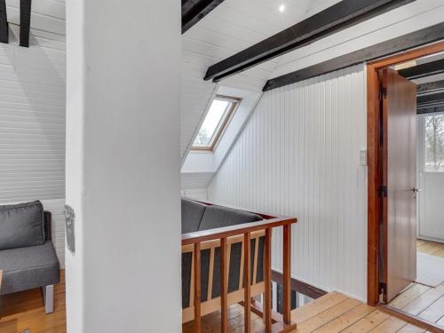 an attic room with a staircase in a tiny house at Holiday Home Bendine - 100m to the fjord by Interhome in Storvorde