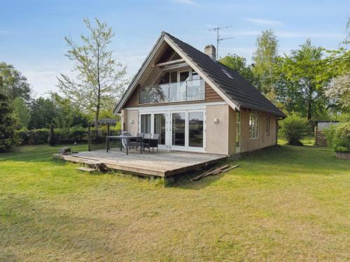 a small house with a deck in the yard at Holiday Home Bendine - 100m to the fjord by Interhome in Storvorde