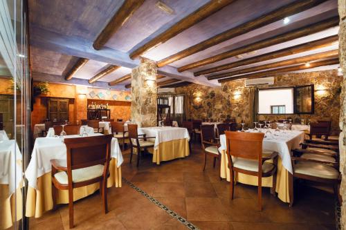 a dining room with white tables and chairs at Hotel Sierra de Cazorla & SPA 3* in Cazorla