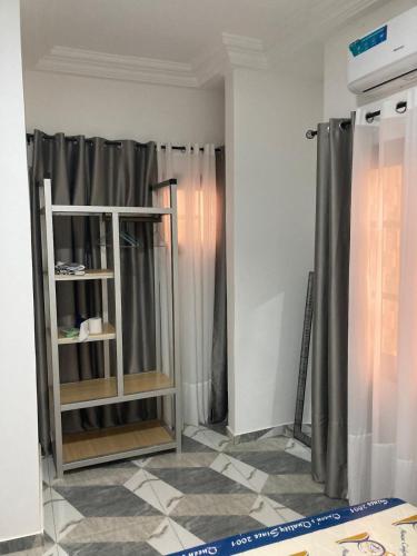a room with gray curtains and a shelf at 2 cozy bedrooms in Lomé Sagbado in Komé