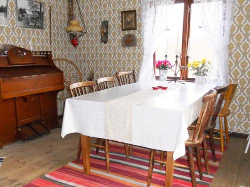 a dining room with a white table and a piano at 6 person holiday home in RYSSBY-By Traum in Agunnaryd