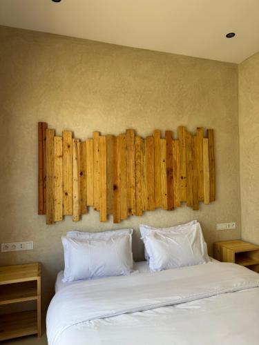 a bedroom with a bed with wooden panels on the wall at SURFHALLA Morocco in Imsouane