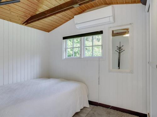 a white bedroom with a bed and a window at Holiday Home Arnborg - 2km from the sea by Interhome in Aså