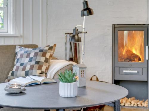 a living room with a coffee table with a fireplace at Holiday Home Arnborg - 2km from the sea by Interhome in Aså