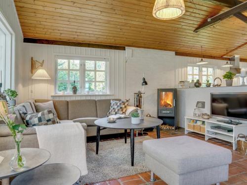 a living room with a couch and a table at Holiday Home Arnborg - 2km from the sea by Interhome in Aså