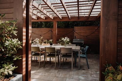 a dining table and chairs under a pergola at Coś miłego in Gowidlino