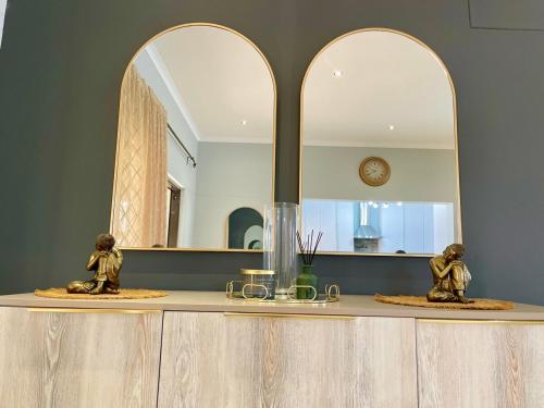 zwei Statuen auf einer Theke vor einem Spiegel in der Unterkunft Omuhama Ocean Escape in Mondesa