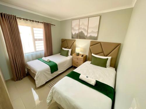 ein Schlafzimmer mit zwei Betten und einem Fenster in der Unterkunft Omuhama Ocean Escape in Mondesa