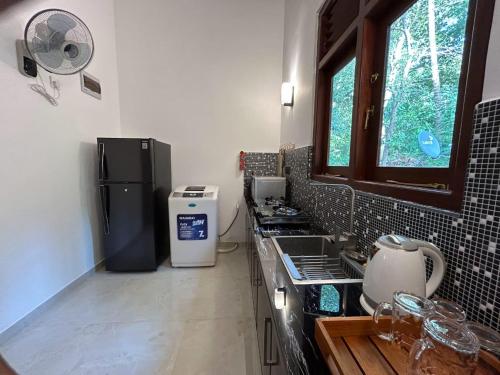 una cocina con fregadero y frigorífico en Villa Rice Edge, en Matara
