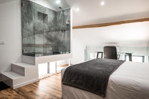a bedroom with a bed and a glass shower at Loft Prestige in Leiria