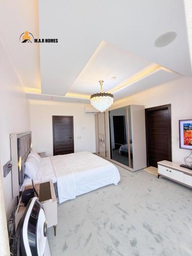 a large bedroom with a large bed and a tv at Obudu villa in Lakowe