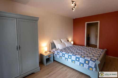 a bedroom with a bed with orange walls at Gite près des gorges du Tarn et du viaduc de Millau in Compeyre