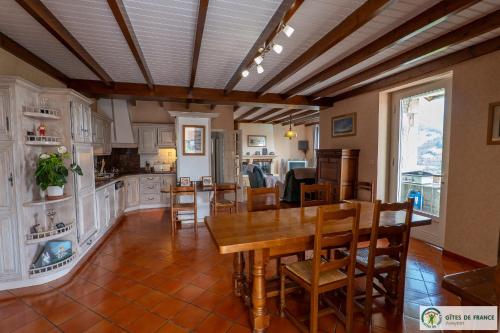 a kitchen and dining room with a table and chairs at Gite près des gorges du Tarn et du viaduc de Millau in Compeyre