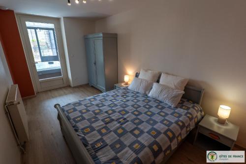 a bedroom with a bed with two lamps and a window at Gite près des gorges du Tarn et du viaduc de Millau in Compeyre