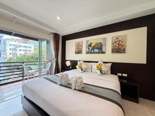 a bedroom with a large bed and a large window at Thai Classic House in Patong Beach