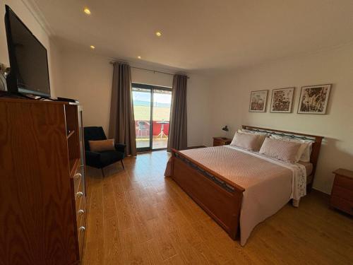 a bedroom with a bed and a television and a chair at Corte Grande in Zebras
