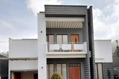 a white house with a balcony on top of it at Omah Soesan in Tawangmangu